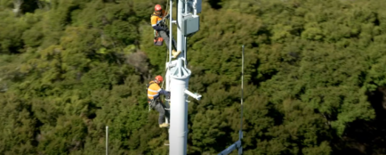 Two men working on a cell site upgrade tower pole